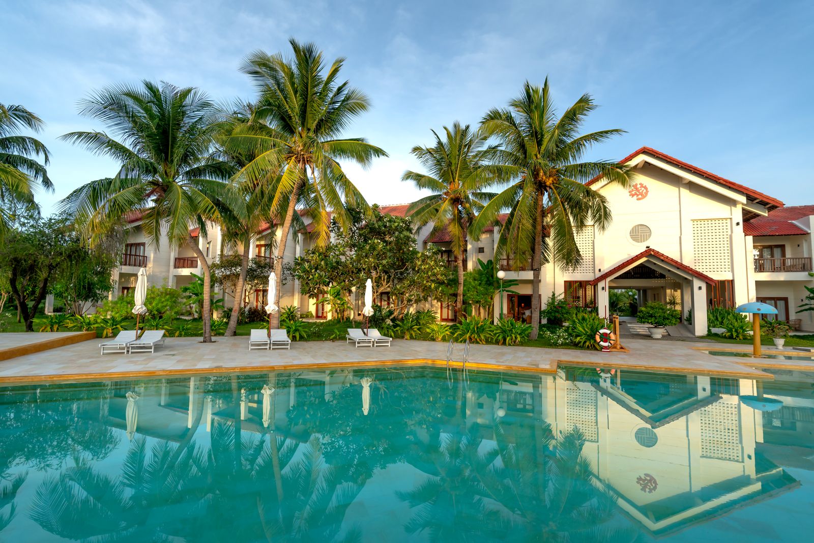 Resort pool with palms and loungers