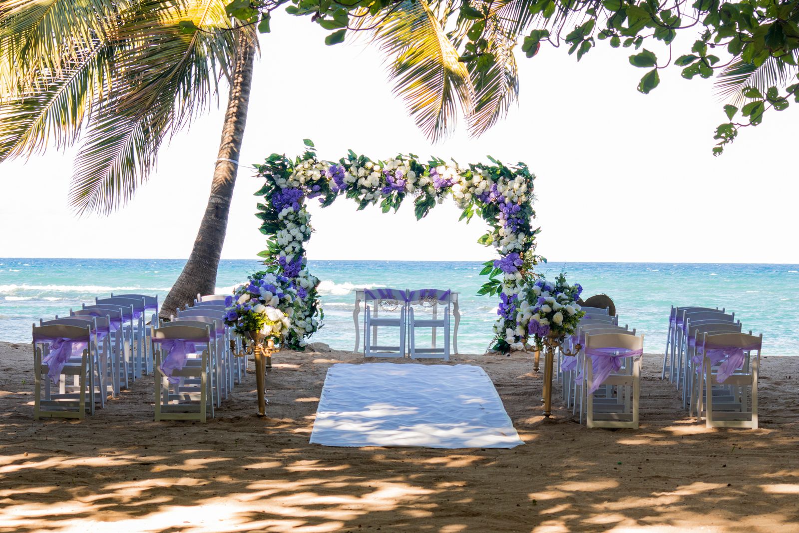 Beach wedding arch with white flowers facing the ocean